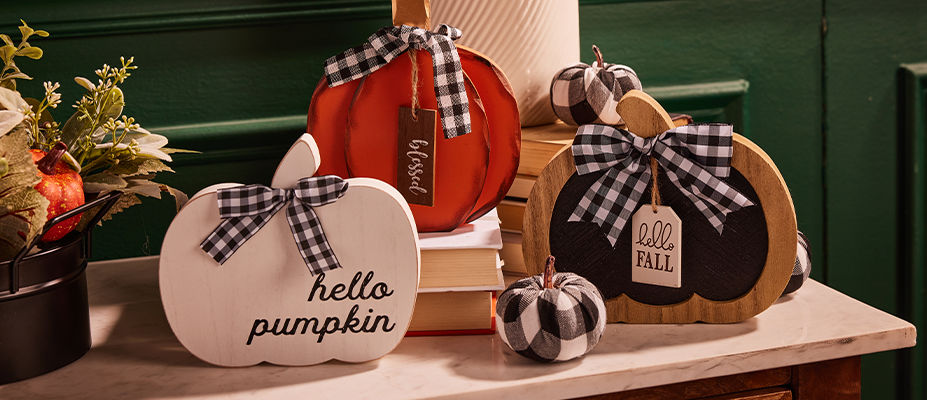 Three wooden pumpkins of different sizes placed on top of a granite counter top.