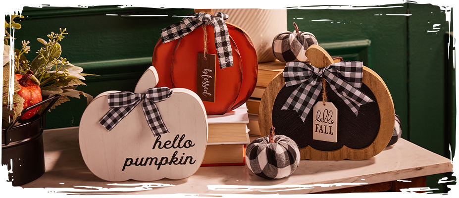 Three wooden pumpkins of different sizes placed on top of a granite counter top.