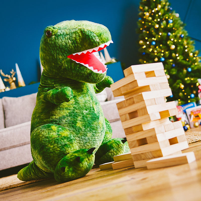 A stuffed green dinosaur and Jenga Blocks.