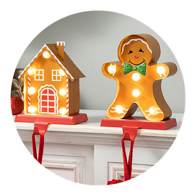 Gingerbread person and gingerbread house stocking holders on a shelf.