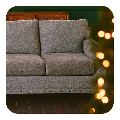 Comfy Gray Sofa next to a Christmas Tree.